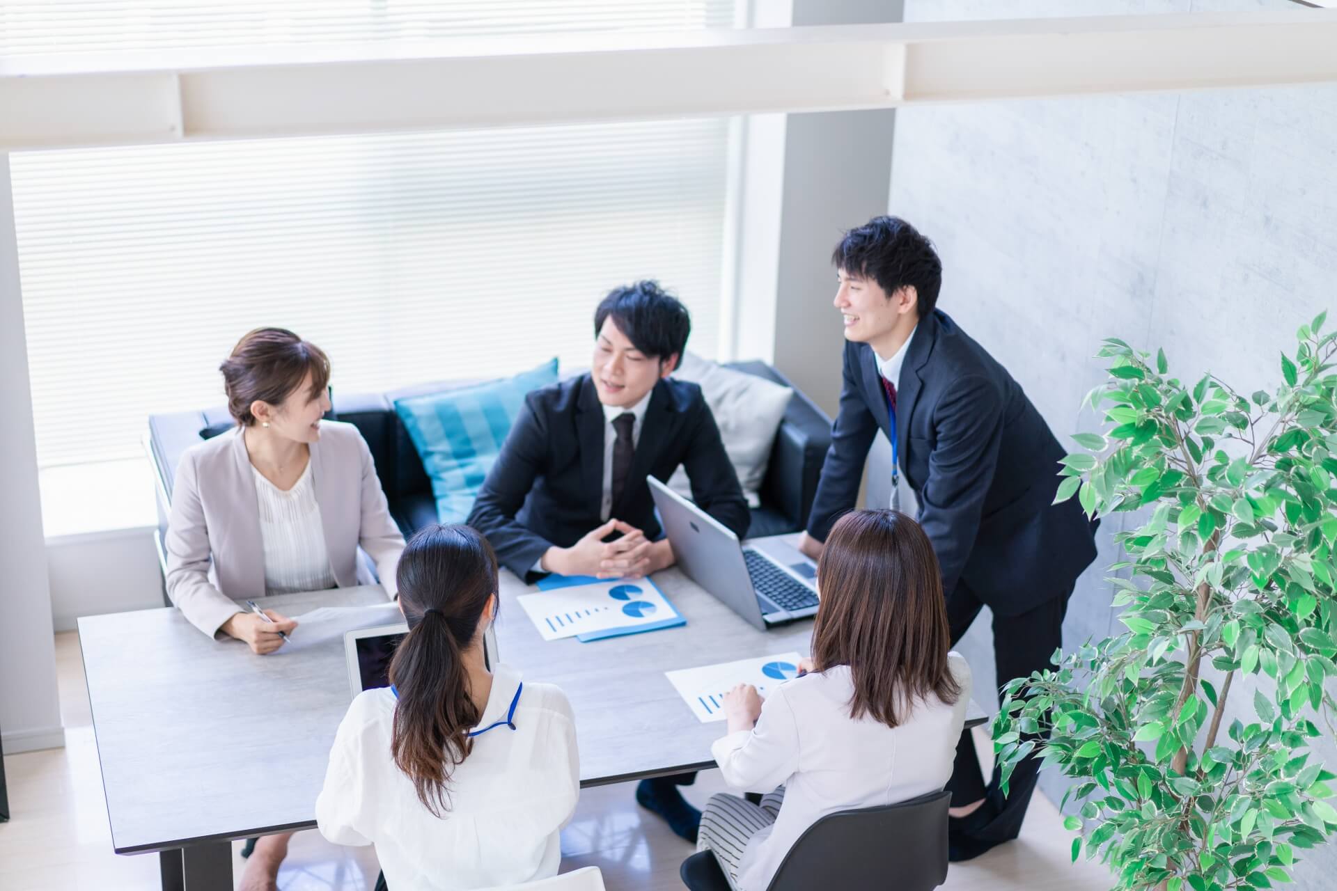 職場環境改善を目的とした、リラックスできる空間でのチームミーティング。社内コミュニケーションを促進する様子。